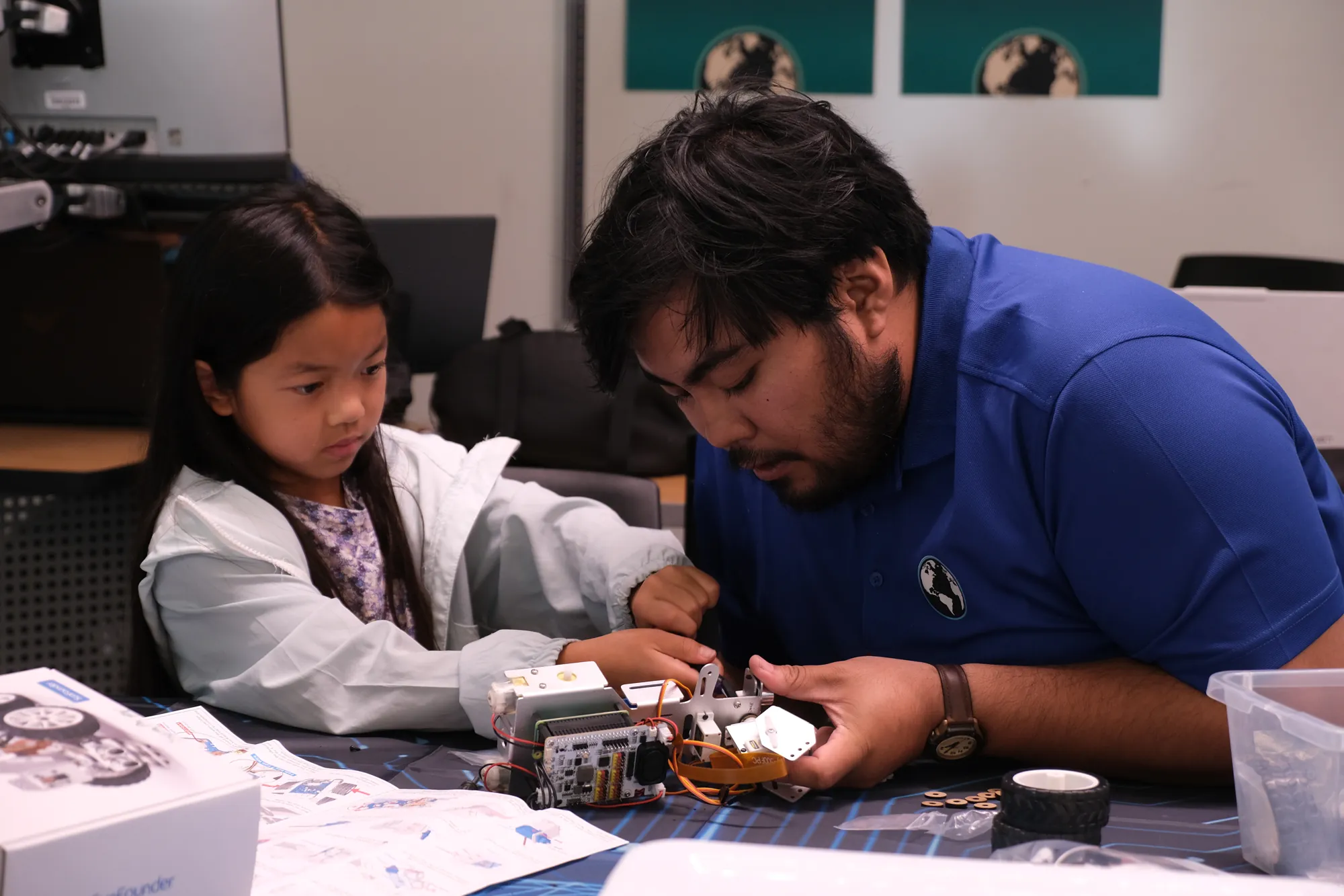 Instructor helping a student with robotics