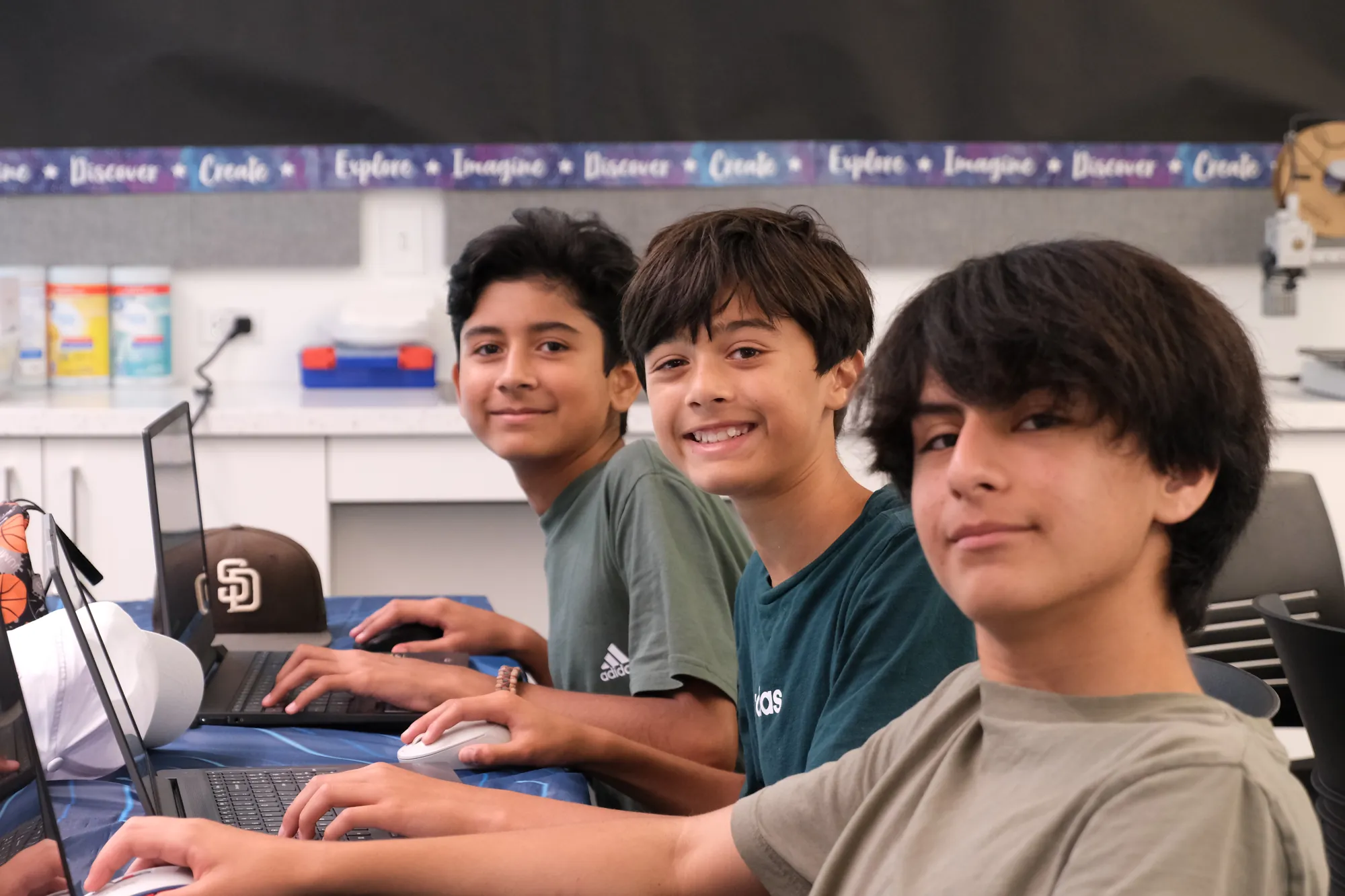 Students smiling while coding