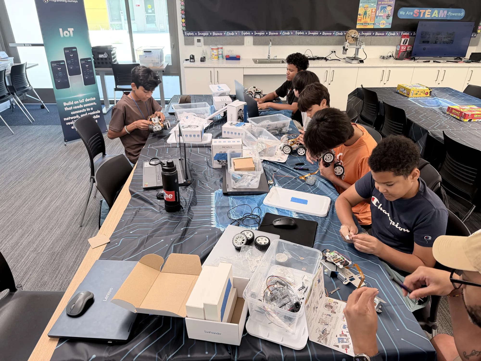 Students building PiCar robots along a table